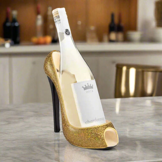 Bottle of white wine in a gold high-heeled shoe on a kitchen counter.