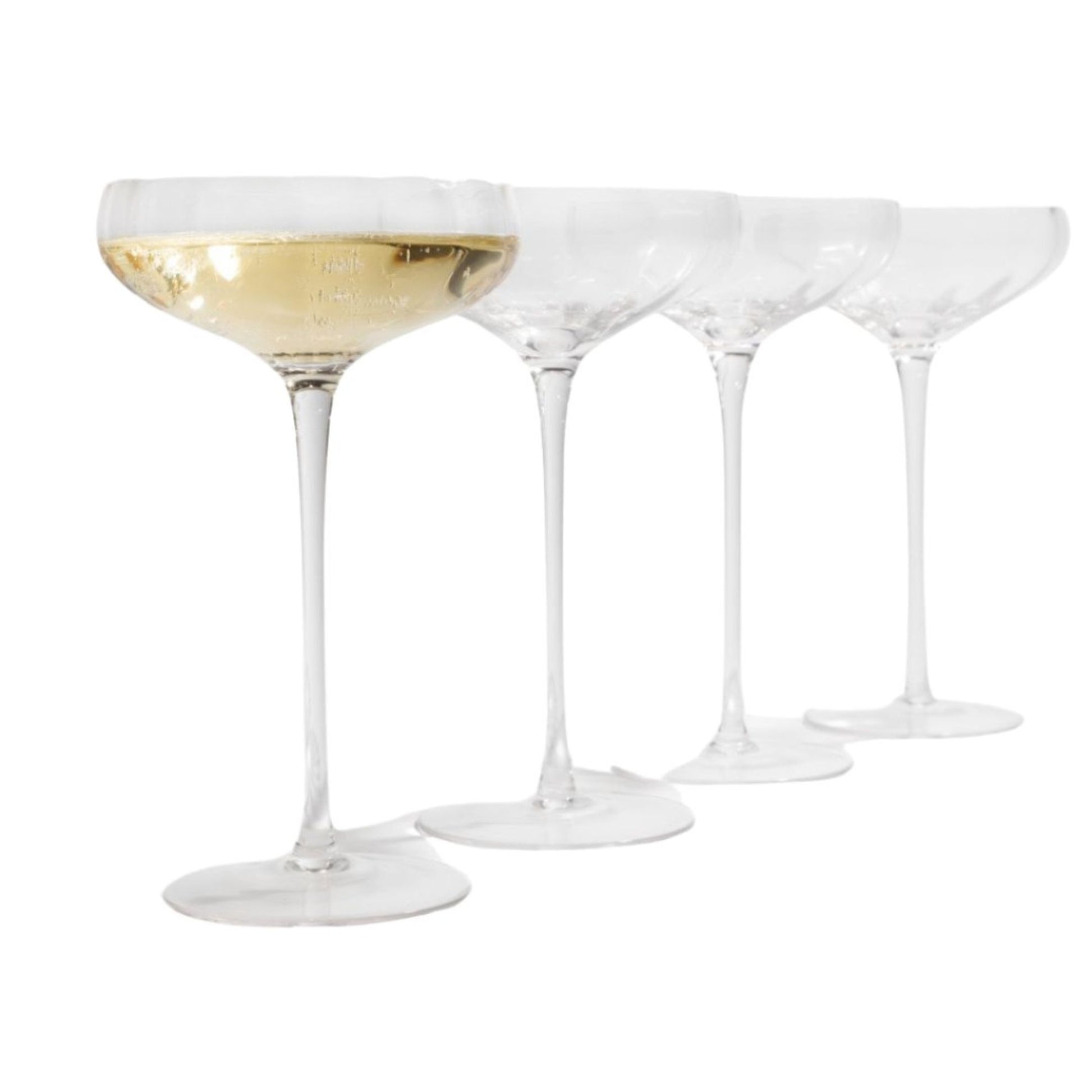Set of four champagne coupe glasses with one filled with champagne on a white background