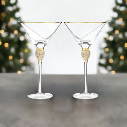 Two decorative martini glasses with gold accents on a neutral background