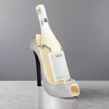 Bottle of white wine inside a high-heeled shoe on a gray background