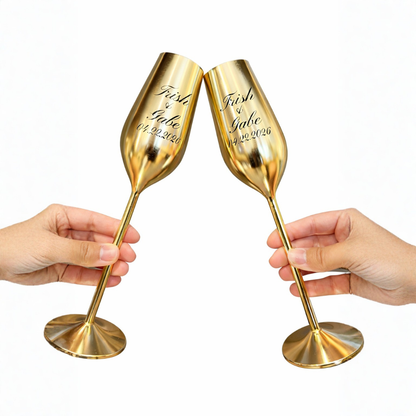 Two gold champagne flutes being held by hands on a white background
