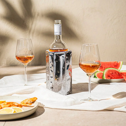 Bottle of wine with two glasses and watermelon on a table outdoors