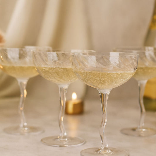 Close-up of champagne glasses with a blurred candle in the background